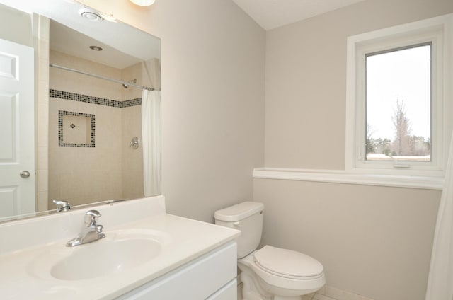 bathroom featuring tiled shower, vanity, and toilet