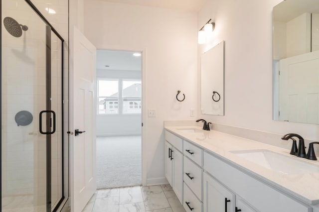 full bath featuring marble finish floor, double vanity, a stall shower, and a sink