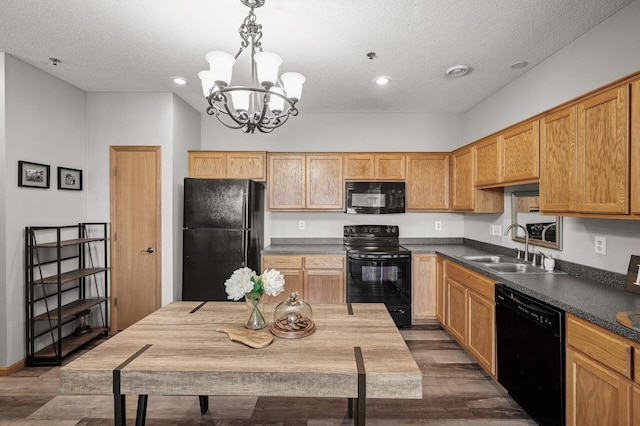 kitchen with dark wood-style floors, dark countertops, a sink, a textured ceiling, and black appliances