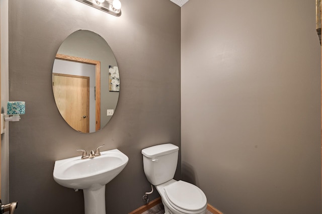 bathroom with toilet and baseboards