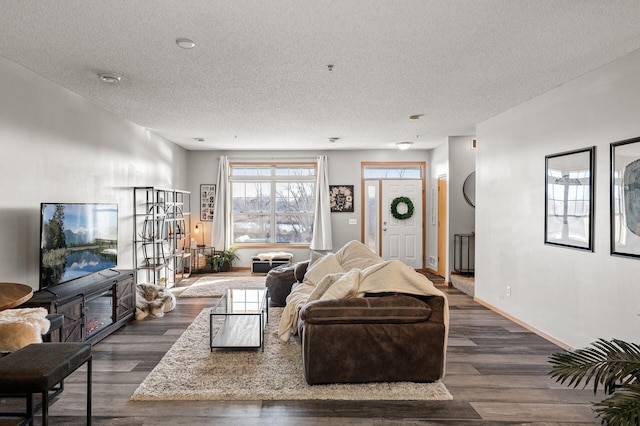 living room featuring a textured ceiling, dark wood finished floors, and baseboards