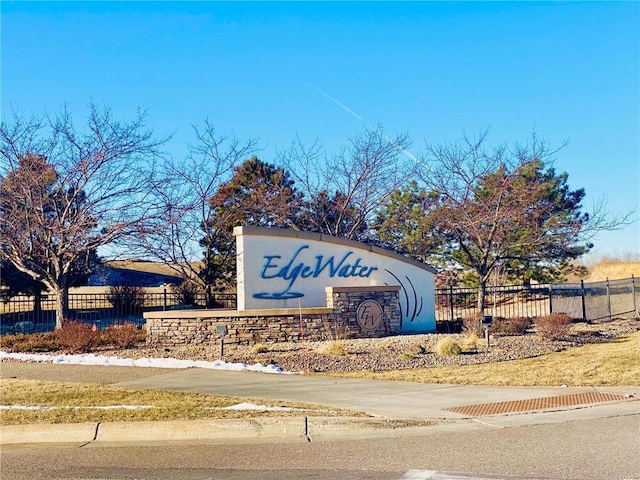 community / neighborhood sign featuring fence