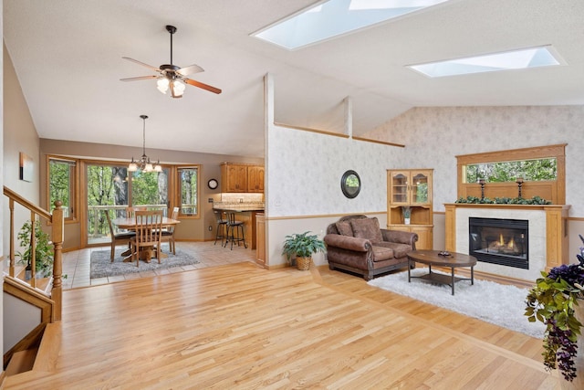 3415 197th Ave NW, Oak Grove, MN 55303 - living area with vaulted ceiling, a skylight, light wood-type flooring, a tile fireplace, and wallpapered walls