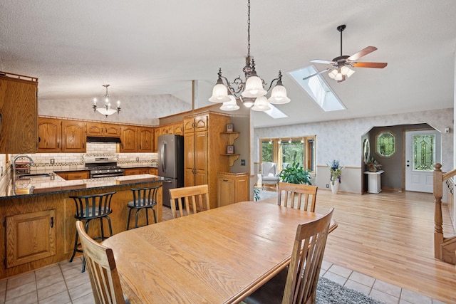 3415 197th Ave NW, Oak Grove, MN 55303 - dining area featuring vaulted ceiling, a chandelier, ceiling fan, light tile patterned floors, and a skylight