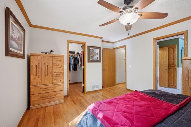 3415 197th Ave NW, Oak Grove, MN 55303 - bedroom with light wood finished floors, a walk in closet, a closet, ornamental molding, and baseboards