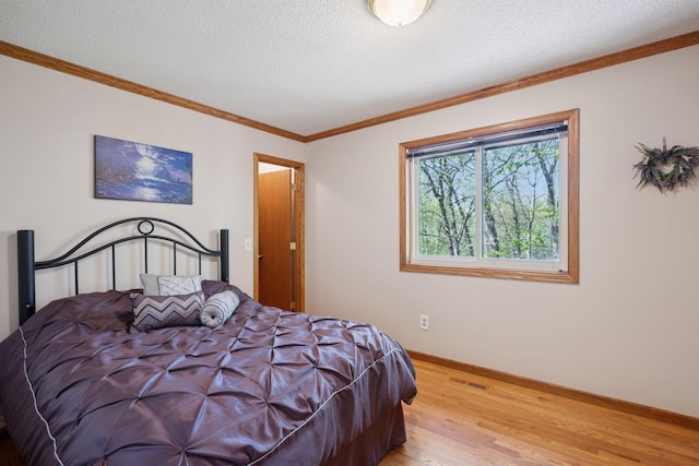 3415 197th Ave NW, Oak Grove, MN 55303 - bedroom featuring light wood-type flooring, baseboards, a textured ceiling, and crown molding