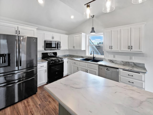 kitchen featuring stainless steel appliances, a sink, white cabinets, vaulted ceiling, and dark wood-style floors