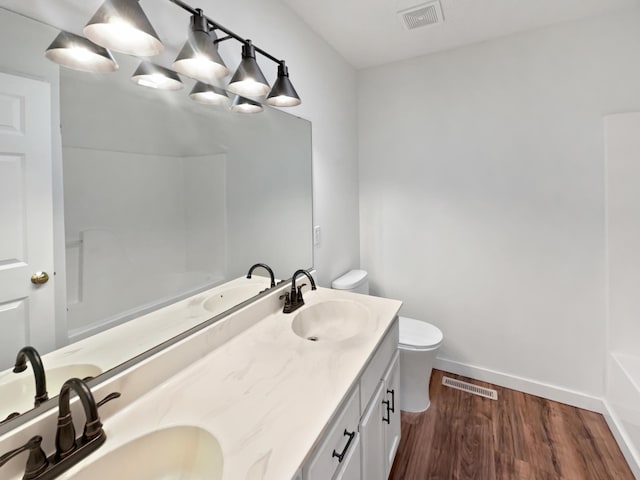 full bath with visible vents, a sink, and wood finished floors