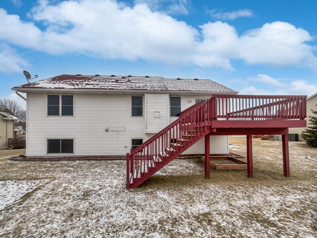 rear view of property featuring stairway, a deck, and roof with shingles