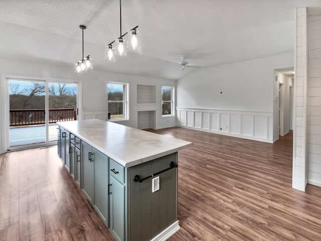 kitchen with lofted ceiling, ceiling fan, wood finished floors, hanging light fixtures, and gray cabinets