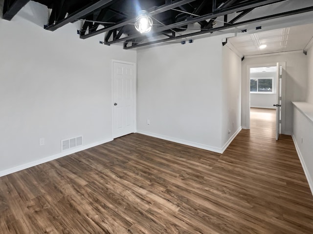 unfurnished room with wood finished floors, visible vents, and baseboards