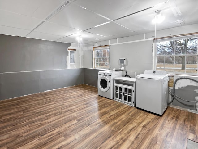 clothes washing area with laundry area, washer and clothes dryer, and wood finished floors