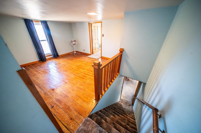 staircase with wood finished floors and baseboards