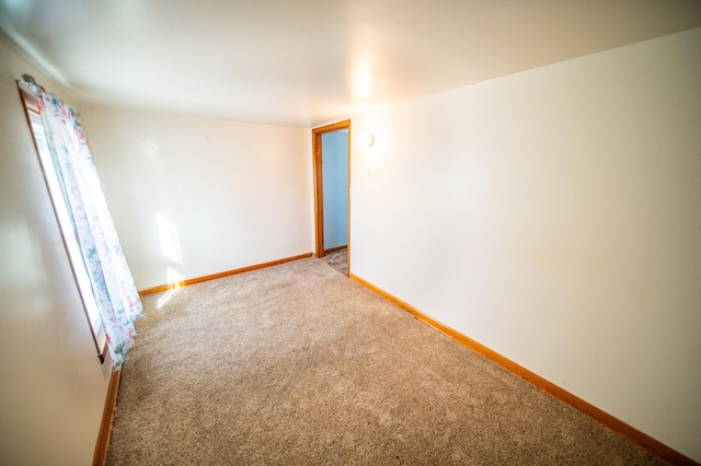 empty room with light colored carpet and baseboards