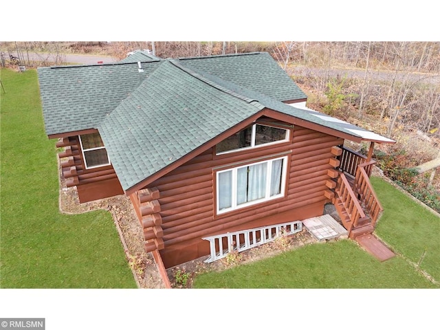 734 180th Ave, Apple River Twp, WI 54810 - view of side of property featuring log siding, a shingled roof, and a lawn