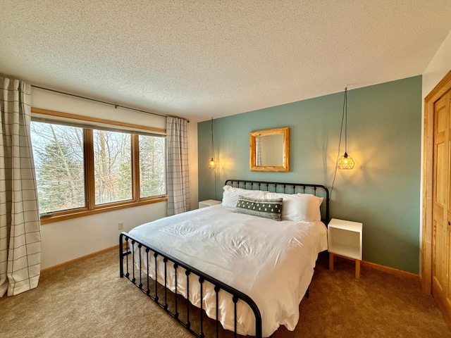 bedroom with a textured ceiling, carpet floors, and baseboards