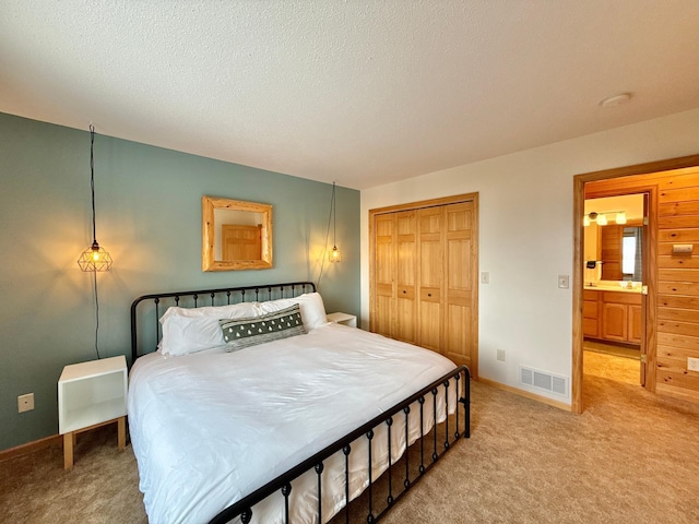 bedroom featuring a closet, visible vents, light carpet, and baseboards