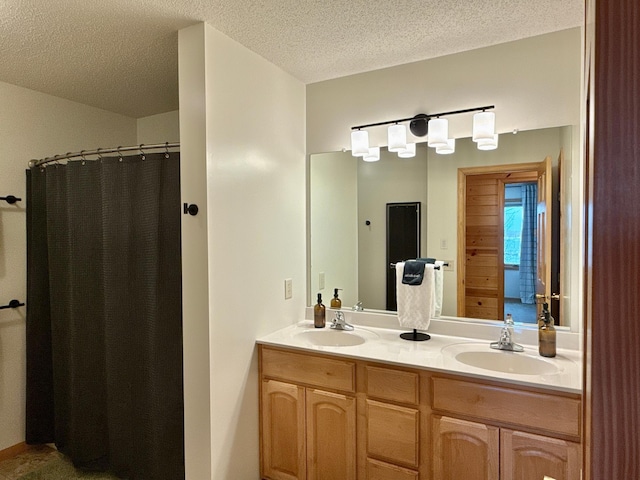 full bathroom with a textured ceiling, double vanity, curtained shower, and a sink