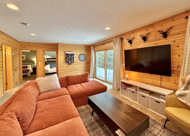 living area with carpet floors, wood walls, a textured ceiling, and recessed lighting