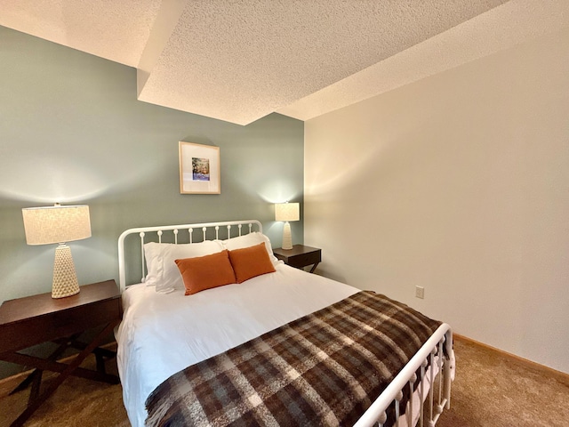 carpeted bedroom featuring baseboards and a textured ceiling