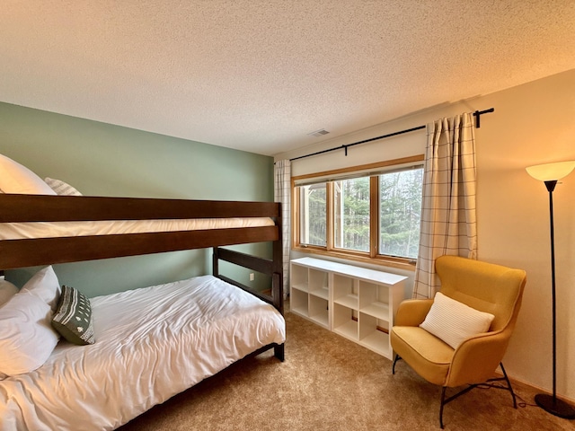 carpeted bedroom featuring visible vents and a textured ceiling