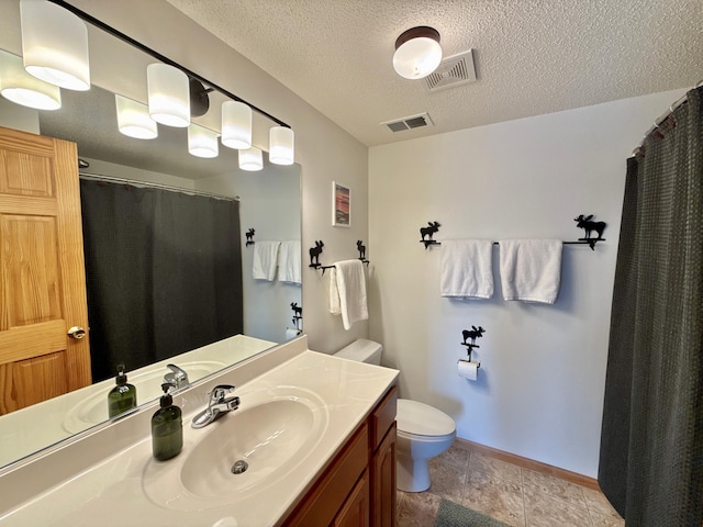 bathroom featuring toilet, visible vents, a textured ceiling, and vanity