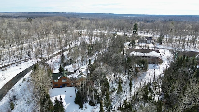 snowy aerial view featuring a forest view