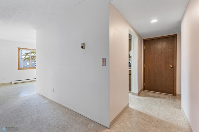 hallway with recessed lighting, light colored carpet, baseboard heating, a textured ceiling, and baseboards