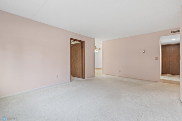 unfurnished room featuring a ceiling fan, light colored carpet, and visible vents