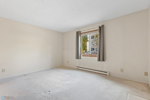 empty room featuring a baseboard heating unit, a textured ceiling, and light colored carpet