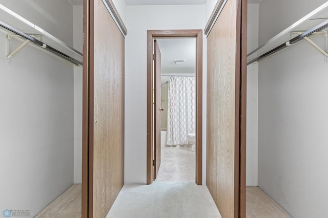 hallway with light carpet and visible vents