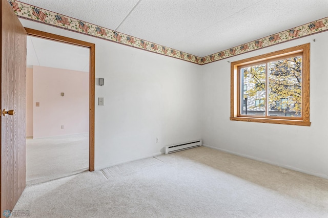 spare room featuring light colored carpet, a textured ceiling, and baseboard heating