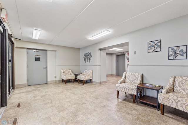 sitting room with visible vents and baseboards