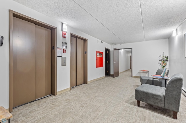 living area with light carpet, elevator, baseboards, and a textured ceiling