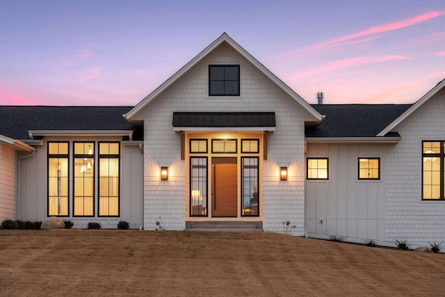 view of front of property with board and batten siding, a standing seam roof, roof with shingles, and metal roof