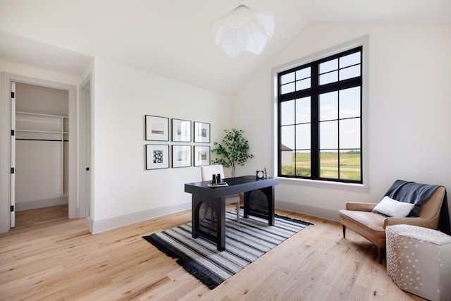 office with high vaulted ceiling, light wood-type flooring, and baseboards