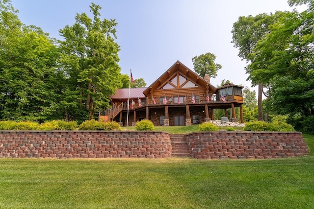 rear view of property with stairs, a deck, and a lawn