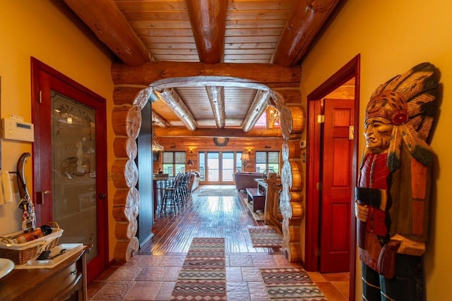 hall with stone tile flooring, wooden ceiling, and beamed ceiling