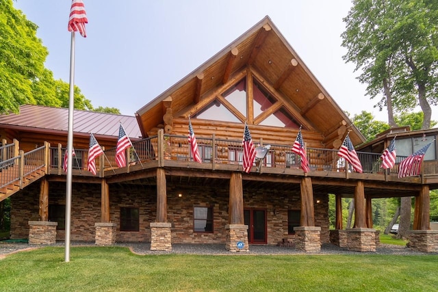 back of house featuring metal roof, a lawn, a wooden deck, and log siding