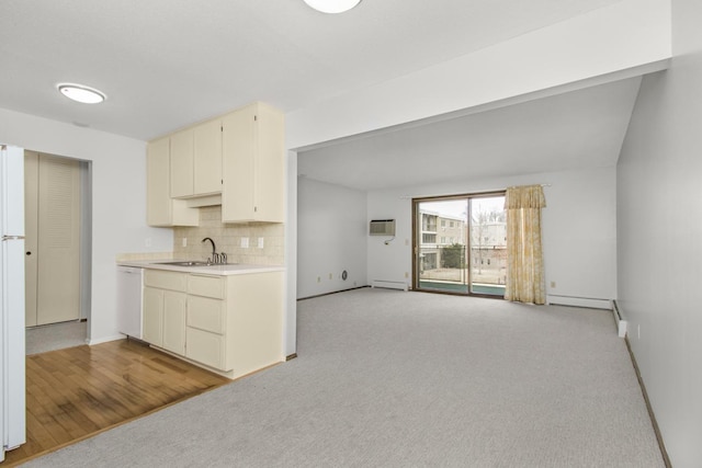 kitchen with light colored carpet, a sink, light countertops, backsplash, and dishwasher