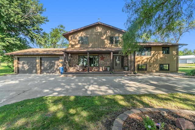 view of front of house featuring covered porch, driveway, brick siding, and an attached garage