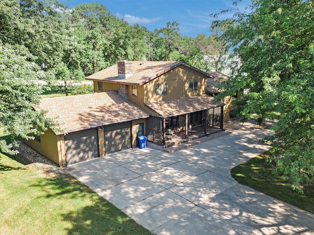 view of front of home with a garage, concrete driveway, and roof with shingles