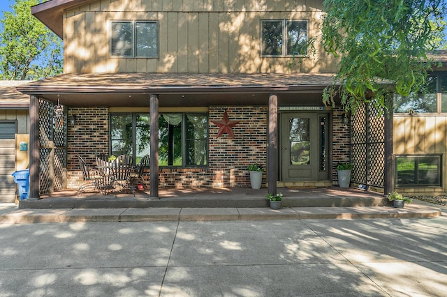 entrance to property featuring a patio area and brick siding