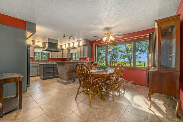 dining room with light tile patterned floors, ceiling fan, a textured ceiling, and a baseboard radiator