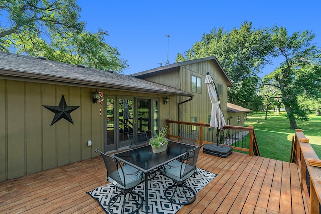 wooden deck with a yard and outdoor dining space