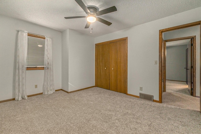 unfurnished bedroom with light carpet, visible vents, and a textured ceiling