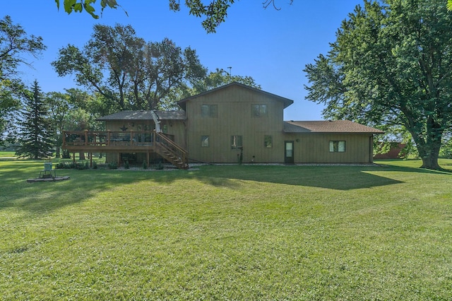 rear view of house with a deck, a yard, and stairway