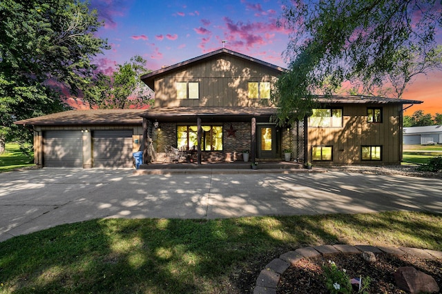 view of front of home with an attached garage, a porch, concrete driveway, and brick siding