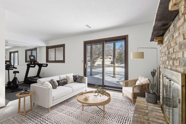 living area featuring a textured ceiling, a fireplace, and carpet flooring