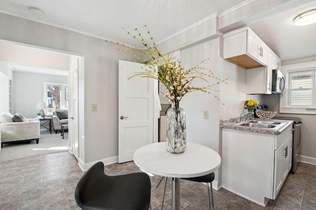 dining area with baseboards, a textured ceiling, and ornamental molding